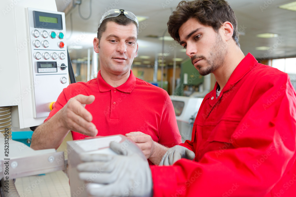 Obraz premium engineer in factory talking to apprentice