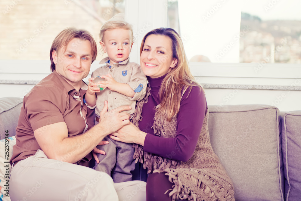 Portrait of happy family sitting on the sofa and smiling.