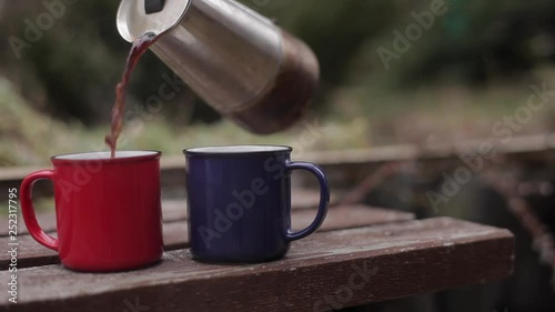 Red and Blue cups of coffee on the wooden bench.