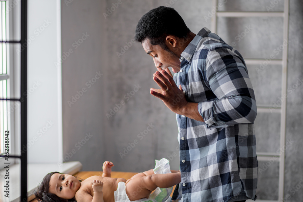funny emotional man having fun with his baby indoors. lifestyle, family