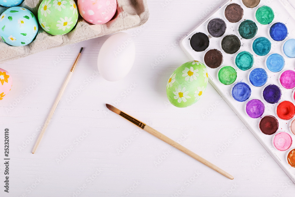 Hand painted Easter eggs, paints and brushes on a white table. Preparation for the holiday. Hand painted Easter eggs, paints and brushes on a white table. Preparation for the holiday.