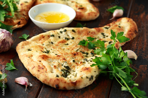 Photos Indian naan bread with garlic butter on wooden table