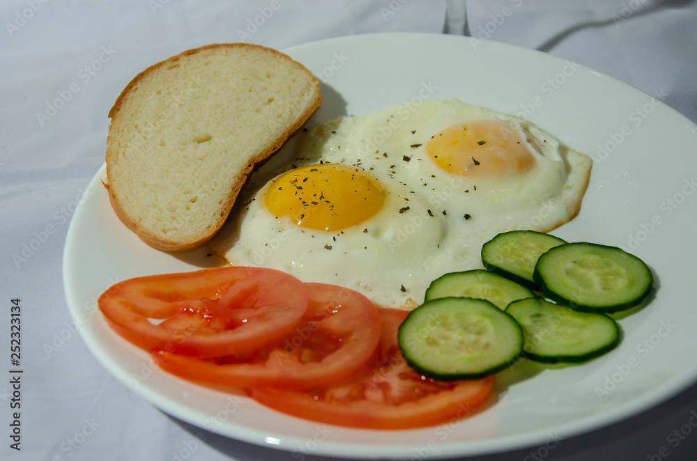 fried chicken eggs with fresh vegetables and bread. Traditional breakfast fried chicken eggs with fresh vegetables and bread. Traditional breakfast