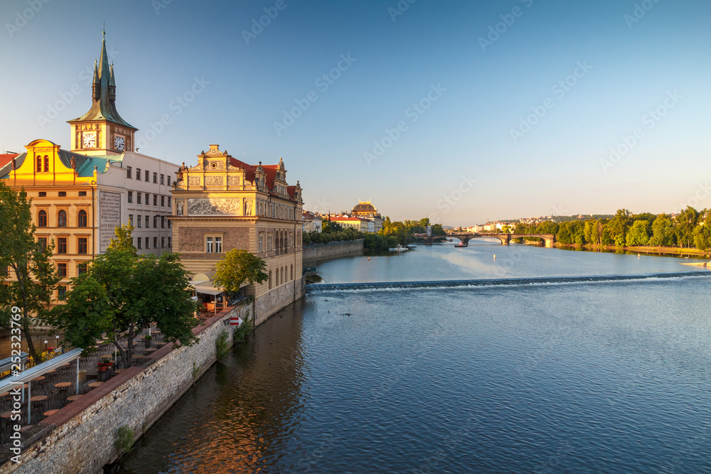 Vltava river and waterfront of the old town with the theater in Prague at sunrise, Czech Republic, Europe.