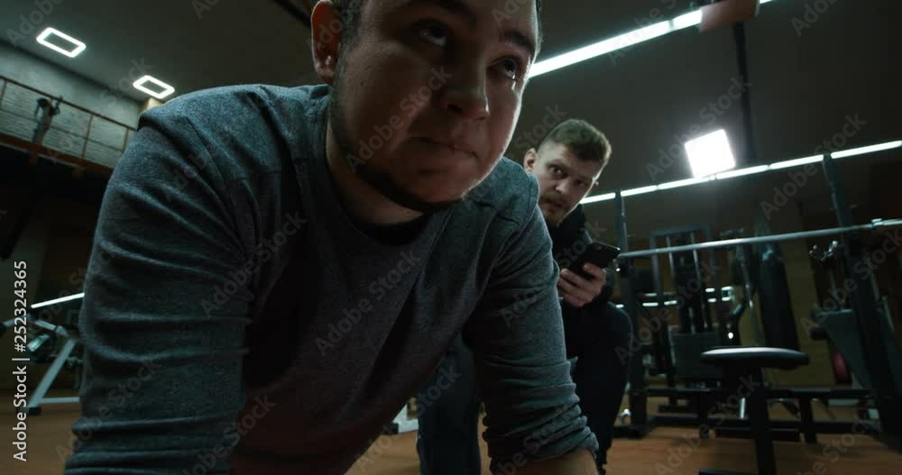 Personal trainer overseeing training of young man Personal trainer overseeing training of young man