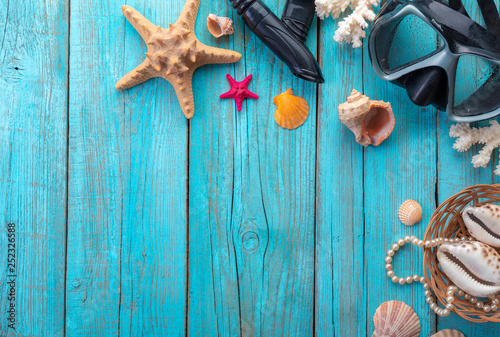 Diving mask with starfish and shells on old blue wooden background. Top view. Flat lay.