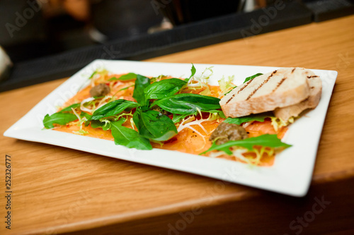 salmon carpaccio on a white plate