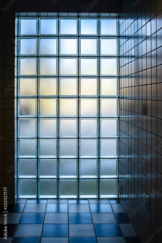 Obraz premium Wall of glass bricks matte color through which the light of day, in the cozy interior of the bathroom.