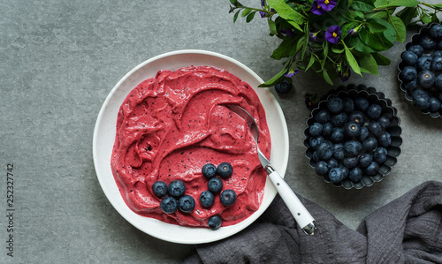 Smoothy of fresh bog blueberries and raspberries in bowl near napkin photo