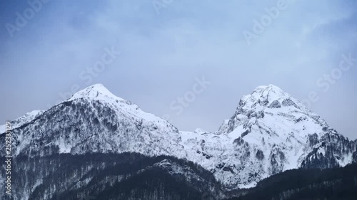 Wallpaper Mural Excellent time-lapse. Two snowy mountain peaks on a background of running clouds Torontodigital.ca