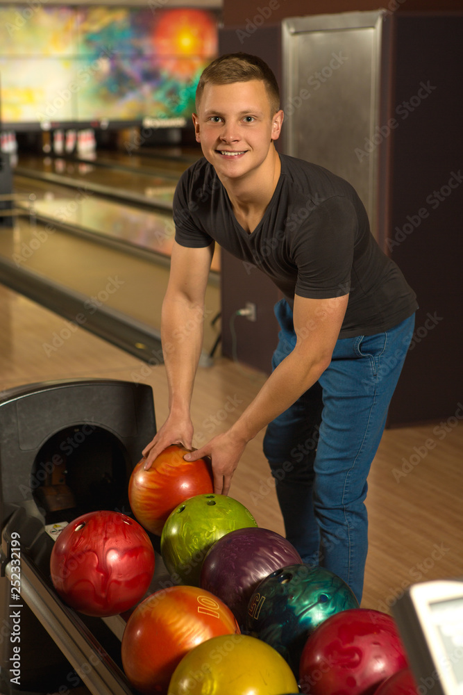 Fototapeta premium Handsome young man playing bowling alone