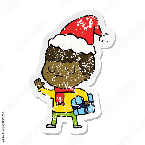 distressed sticker cartoon of a grumpy boy wearing santa hat