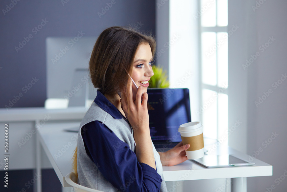Focused attentive woman in headphones sits at desk with laptop, looks at screen, makes notes, learns foreign language in internet Focused attentive woman in headphones sits at desk with laptop, looks at screen, makes notes, learns foreign language in internet