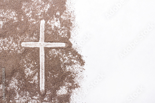 Cross and ash on white background - symbol of Ash Wednesday. Copy space