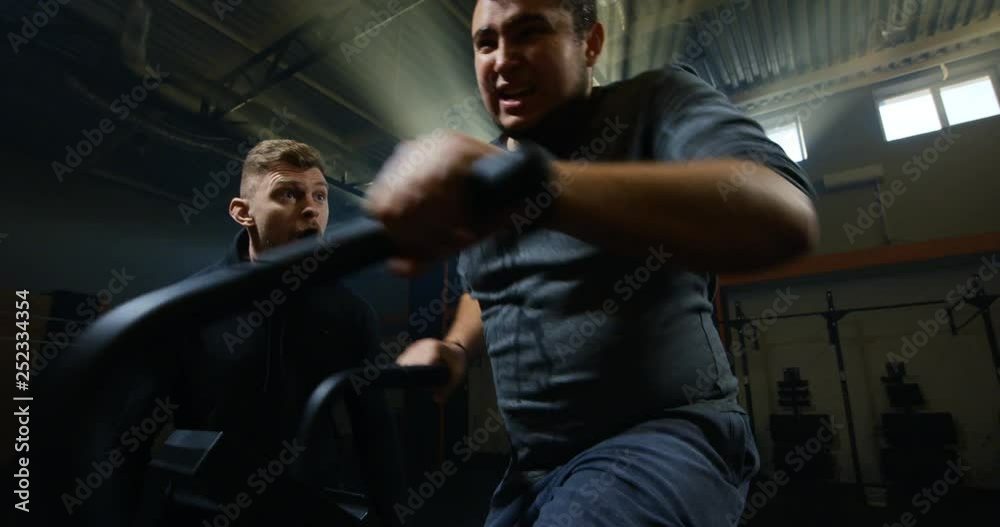 Overweight young man exercising with a machine Overweight young man exercising with a machine