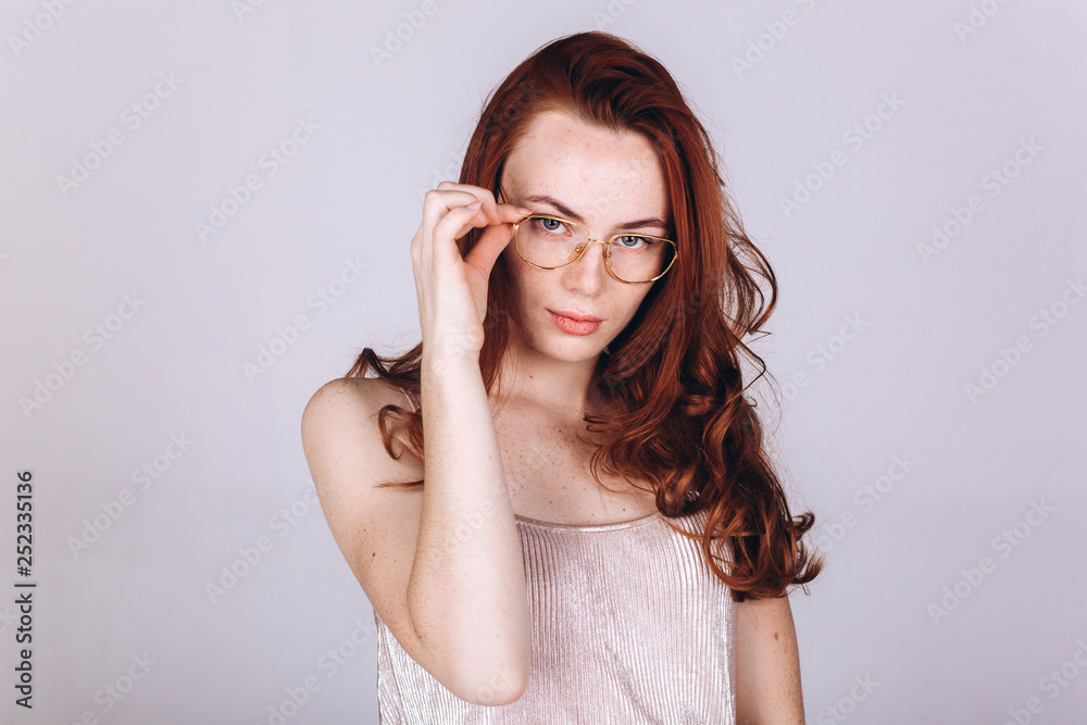 Young serious tender depressed sensual ginger woman on grey background Young serious tender depressed sensual ginger woman on grey background