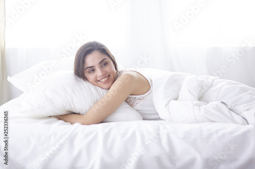 beautiful young woman basking in bed in the morning. Beautiful Model face looks sexy in camera
