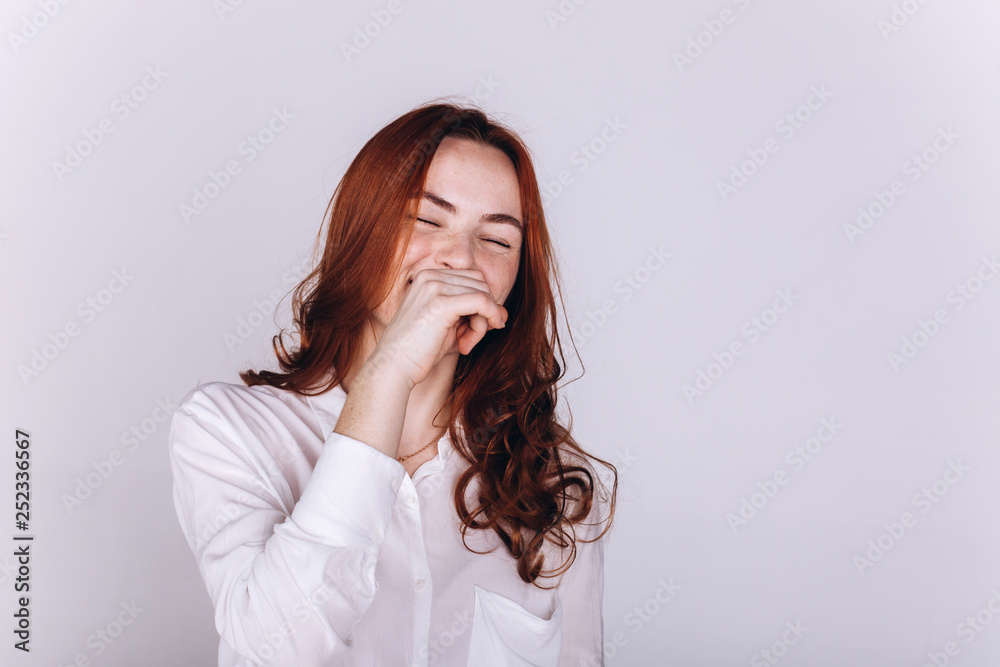 Close up portrait of young ginger pretty emotional caucasian girl with freckles posing in studio on grey background. Beauty, casual, fashion concept Close up portrait of young ginger pretty emotional caucasian girl with freckles posing in studio on grey background. Beauty, casual, fashion concept