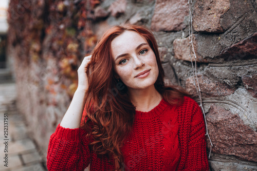 Close up outdoor portrait of caucasian ginger dreaming and smiling sensual tender young girl in autumn park. Beauty, nature, seasons, emotions concept