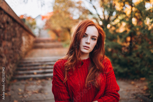 Close up outdoor portrait of caucasian ginger dreaming and smiling sensual tender young girl in autumn park. Beauty, nature, seasons, emotions concept