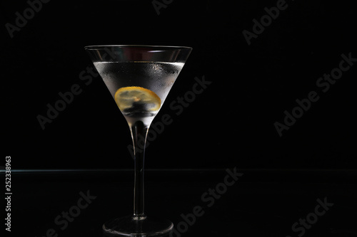 Martini in chilled glass with lemon twist on black background