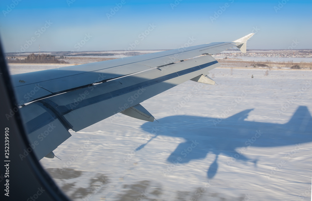 Obraz premium view from the airplane's porthole to the winter plain