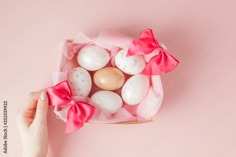 White Easter eggs in a nest on pink background. Design pastel tone in minimal flat lay White Easter eggs in a nest on pink background. Design pastel tone in minimal flat lay