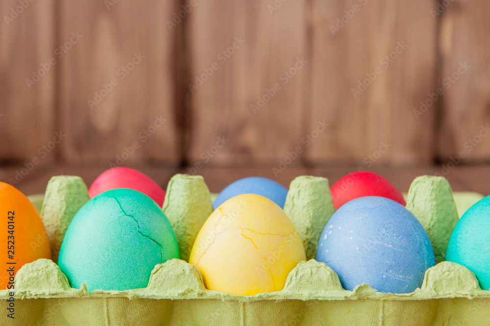 Colorful Easter eggs in box on wooden background with copy space Colorful Easter eggs in box on wooden background with copy space
