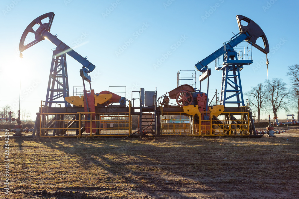 oil production tower while working in backlight against a blue sky oil production tower while working in backlight against a blue sky