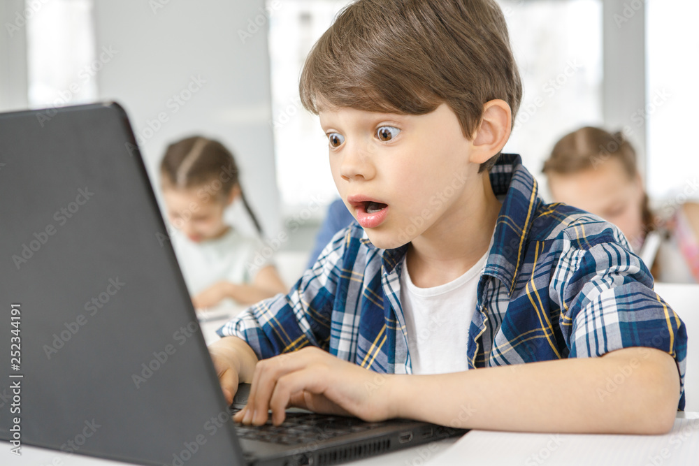 Little boy looking excited using laptop while studying Little boy looking excited using laptop while studying