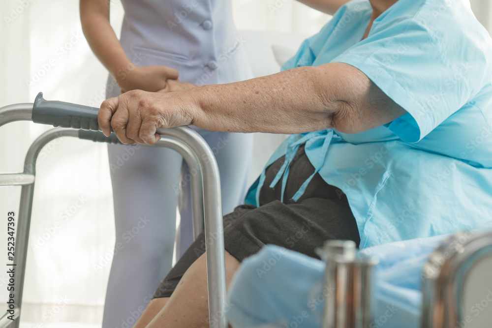 caregivers help elderly to walk in the physical therapy.a caregivers help elderly to walk in the physical therapy.a
