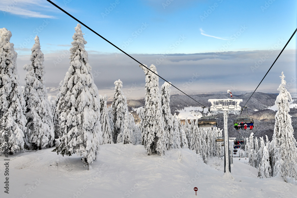 Poiana Brasov, Romania -16 January 2019:Chair lift in Poiana Brasov ski resort, Skiers and snowboarders enjoy the ski slopes in Poiana Brasov winter resort whit forest covered in snow on winter season Poiana Brasov, Romania -16 January 2019:Chair lift in Poiana Brasov ski resort, Skiers and snowboarders enjoy the ski slopes in Poiana Brasov winter resort whit forest covered in snow on winter season
