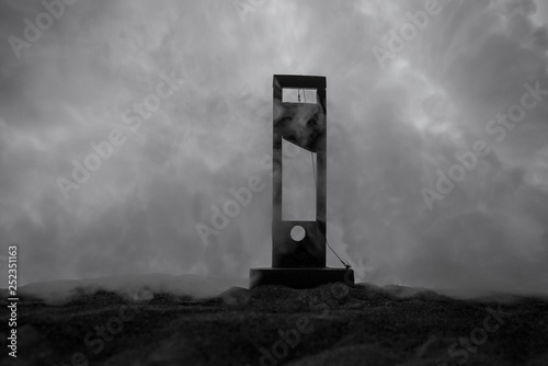 Horror view of Guillotine. Close-up of a guillotine on a dark foggy background. photo