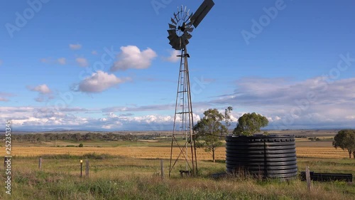 Establishing shot of Australian countryside and famland near Darlington Downs Allora, Queensland with weathervane windmill. photo