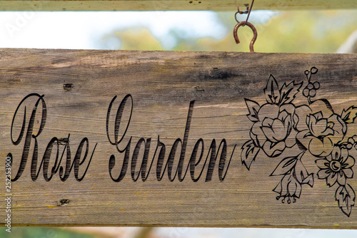 Tableau sur toile A rose-garden sign made of wood and hand painted hanging in front of the botanical garden