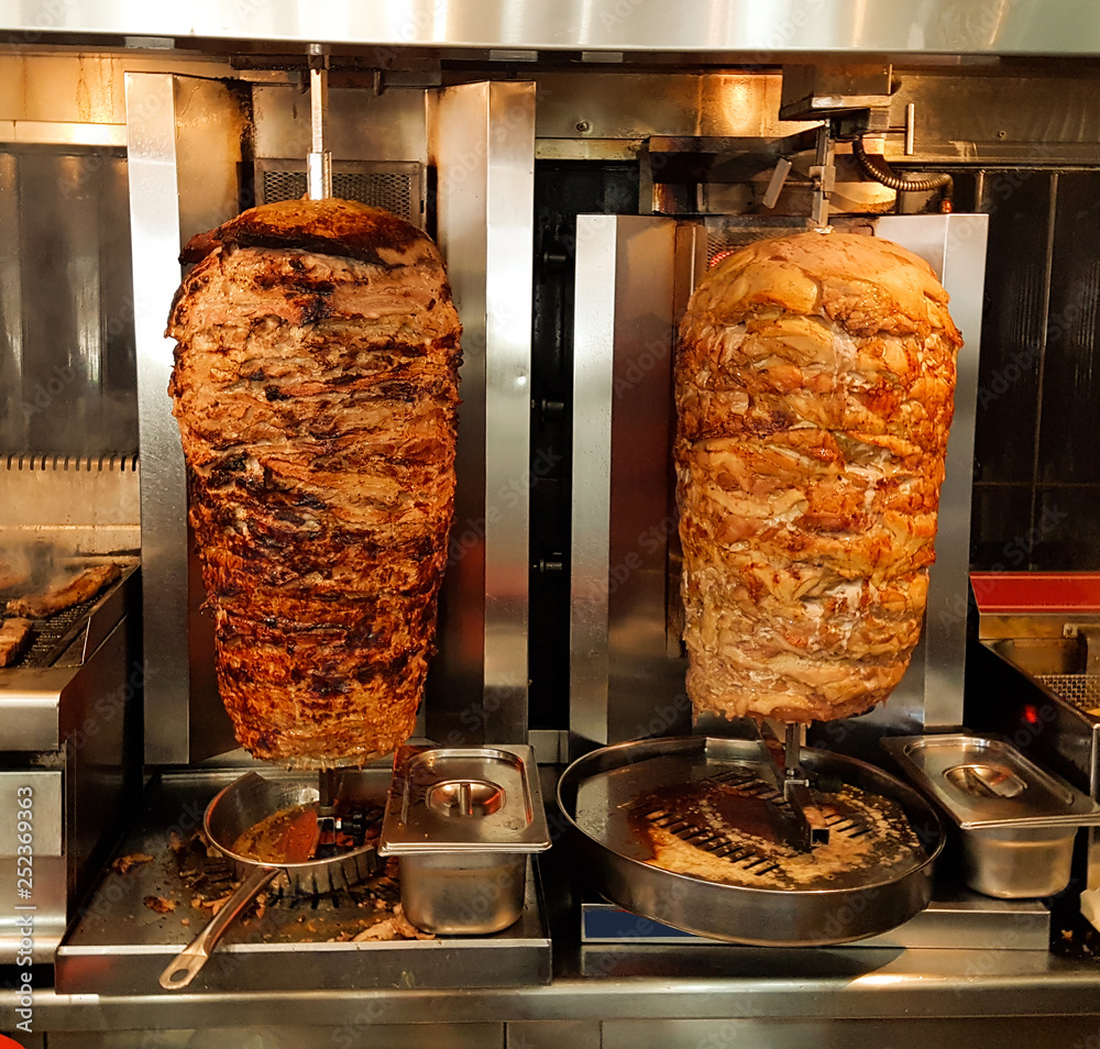 giros meat is baked in the barbecue greek name gyros foto de Stock | Adobe  Stock