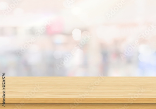Empty wood table top on blur abstract background from inside shopping mall. Template mock up for display of product