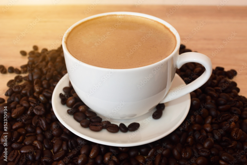 People holding coffee mugs drinking coffee on the table and coffee beans People holding coffee mugs drinking coffee on the table and coffee beans