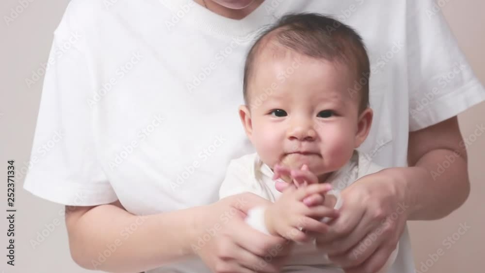 Little asian baby girl playing and clapping the hand with her mother on the white background, New family and baby healthy concept Little asian baby girl playing and clapping the hand with her mother on the white background, New family and baby healthy concept