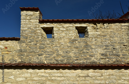 mittelalterliche stadtmauer vor blauem himmel mit fensteröffnungen photo