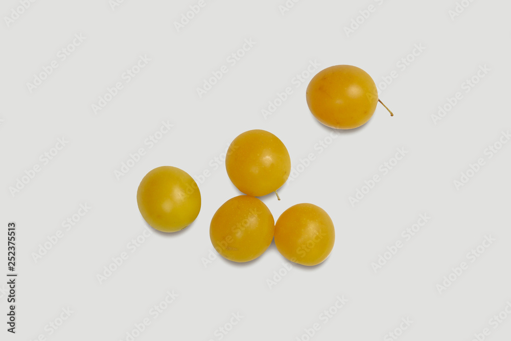 Sweet yellow plums on soft gray background.
