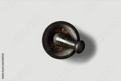 Old cast-iron mortar with pestle isolated on white.different spices inside.Top view.