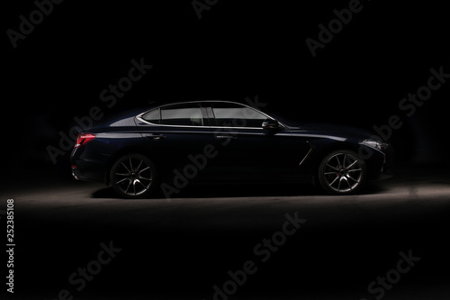Four-door sport coupe. Silhouette of black sports car with headlights © kalinichenkod