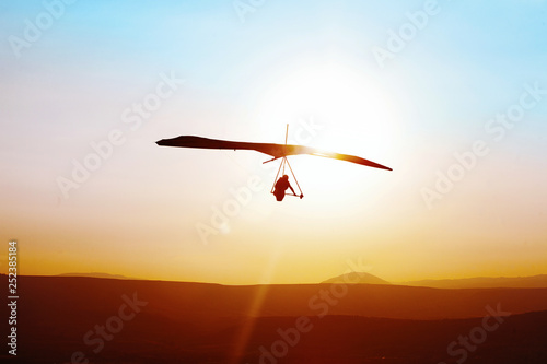 Hang-glider  flight in sky in sunset time over the .Galilean hills, Mevo Hama, Israel photo