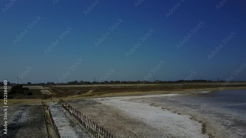 Drone video of deep pink-colored salt lake and wooden logs, upper view Drone video of deep pink-colored salt lake and wooden logs, upper view