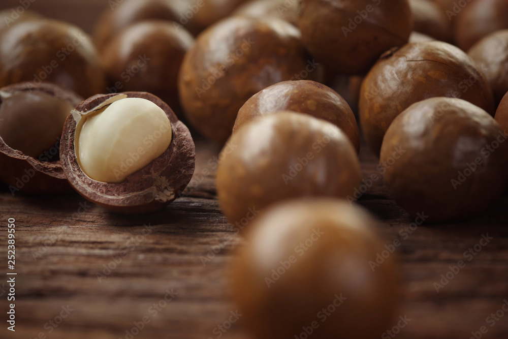 Roasted macadamias on wooden table, selective focus and toned image. Healthy food concept, free space for text. Roasted macadamias on wooden table, selective focus and toned image. Healthy food concept, free space for text.