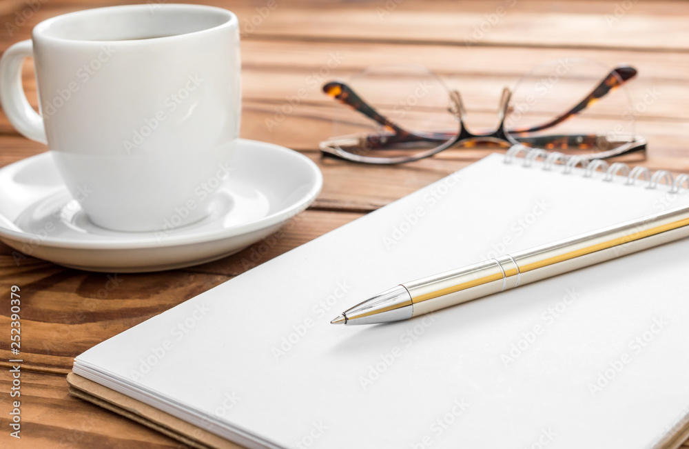 Blank notepad with eyeglasses nad cup of coffee on the table. Blank notepad with eyeglasses nad cup of coffee on the table.