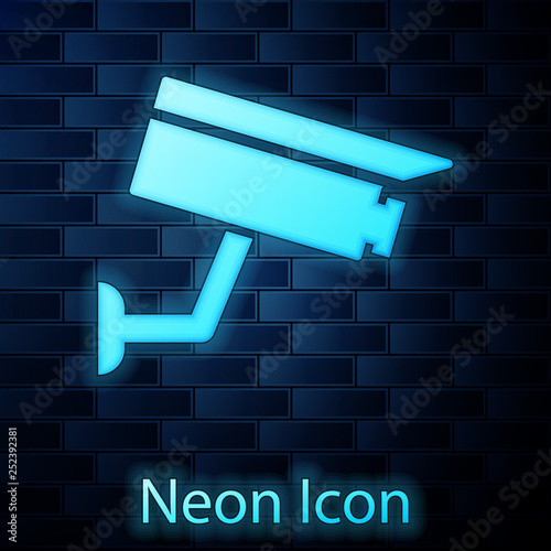 Glowing neon Security camera icon isolated on brick wall background. Vector Illustration
