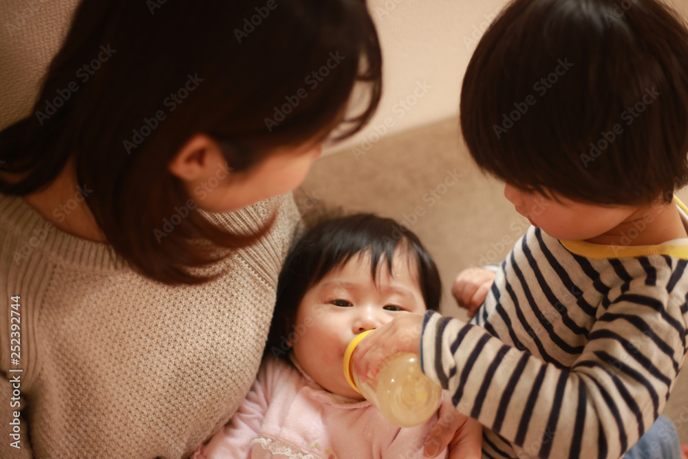 赤ちゃんにミルクを与える親子 赤ちゃんにミルクを与える親子