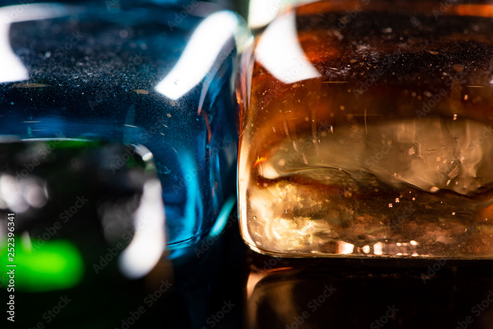 Macro photo of glass cubes of different colors on a black background with reflections